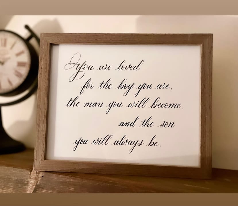 A framed hand-lettered quote reading You are loved for the boy you are