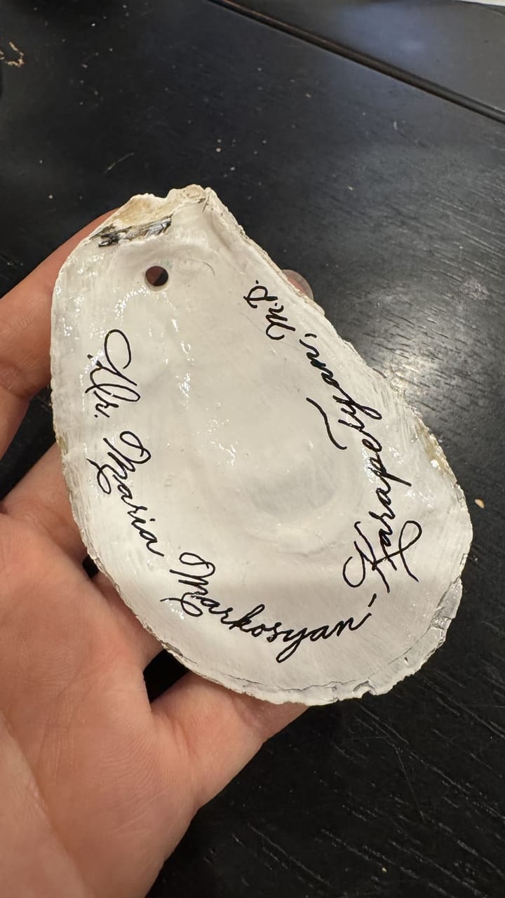 A hand-lettered name tag on a clam shell