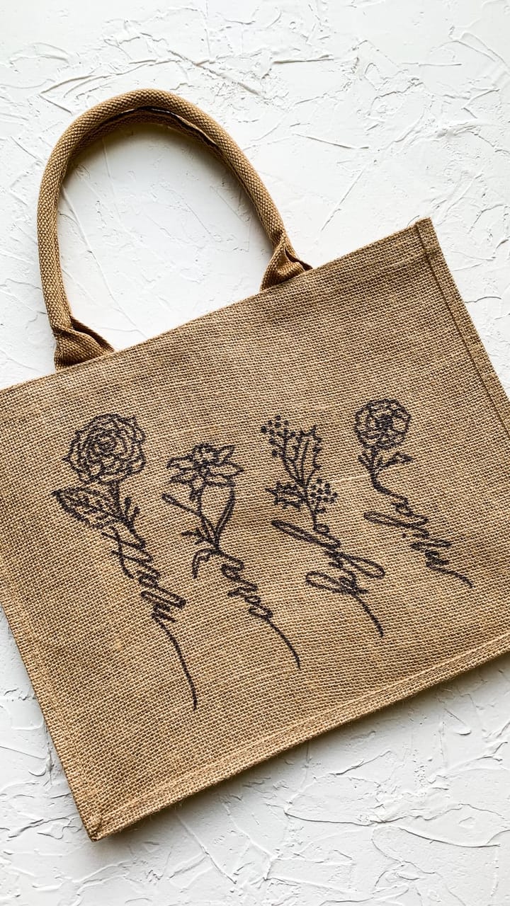 Jute tote bag hand-lettered with a script bouquet of illustrated flowers