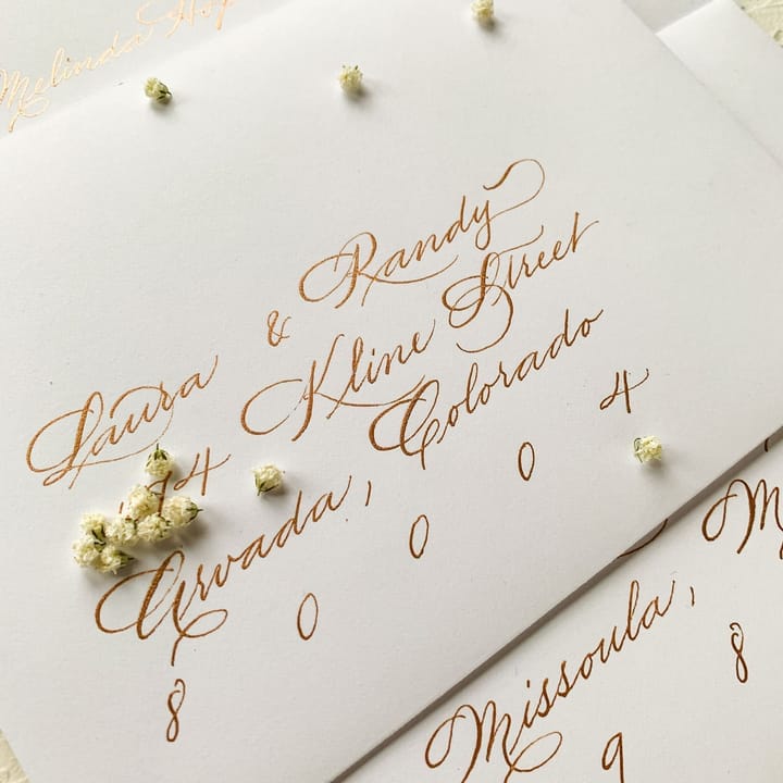 Envelope addressing in copper ink surrounded by dried baby's breath