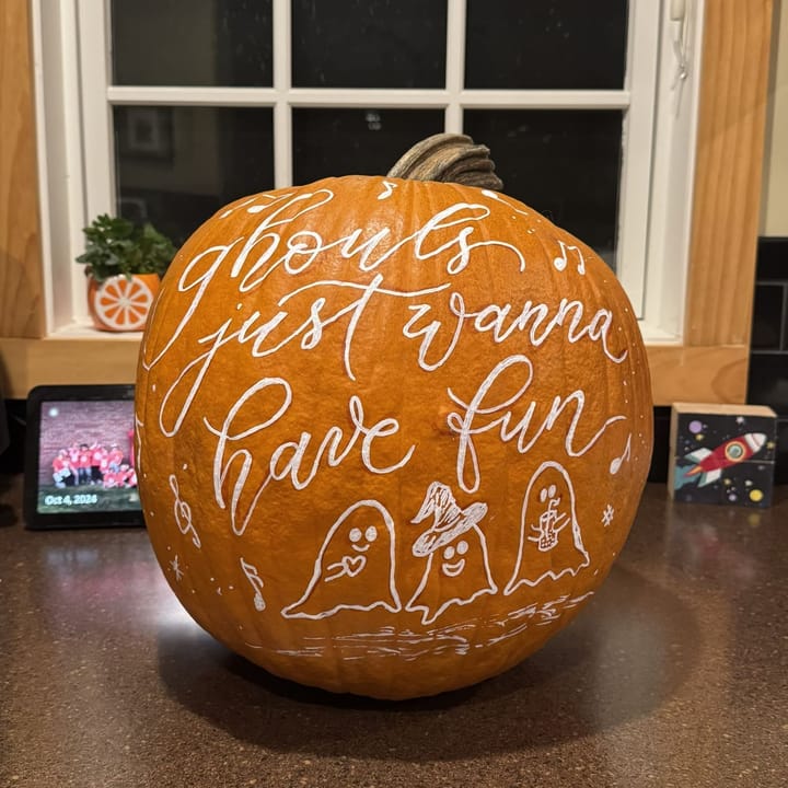 A hand-lettered pumpkin reading ghouls just wanna have fun with painted ghosts
