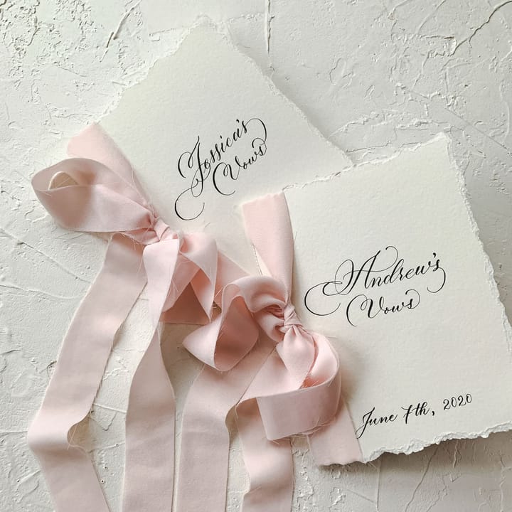 Vow books tied with blush silk ribbon